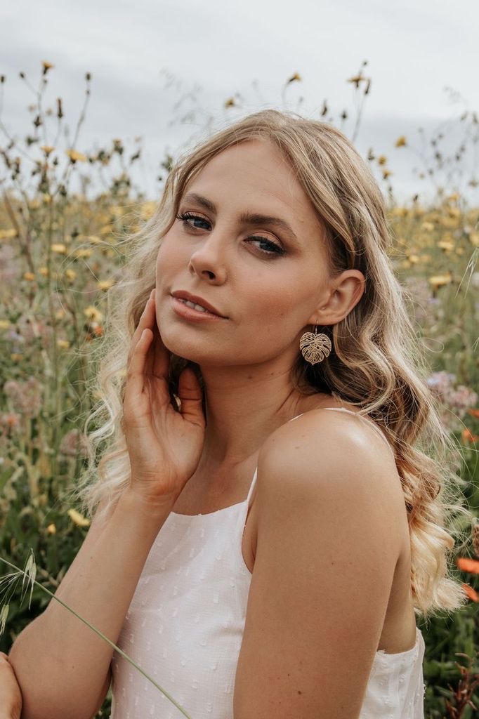 Model wears Wisteria London Gold Monstera Earrings