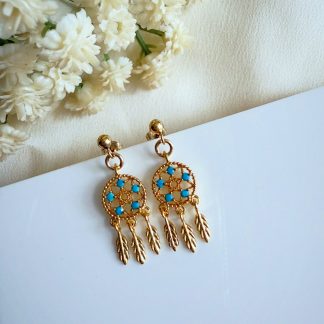 A pair of gold dreamcatcher stud earrings featuring a fine web design with small feather details.
